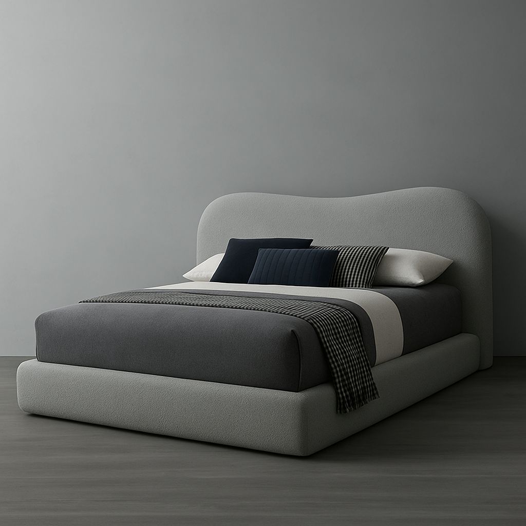 Modern bed with gray upholstered headboard and bedding against a gray wall.