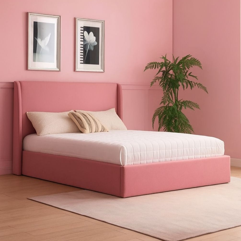 Pink bed in a room with pink walls, a plant, and framed pictures.