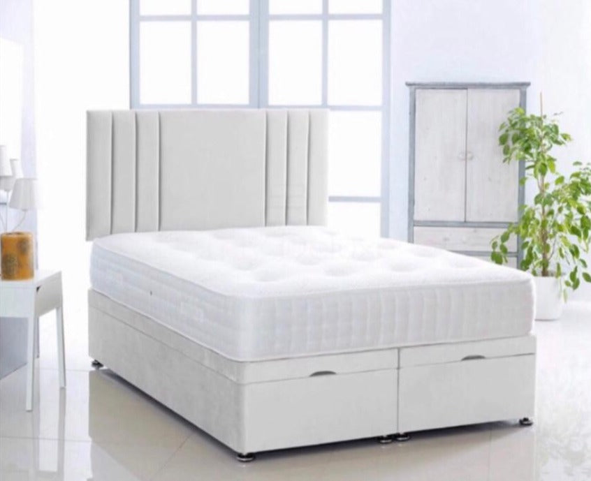A white wall bed with a floor-standing headboard and a solid ottoman divan beneath. The headboard features three elegant vertical lines on each side.